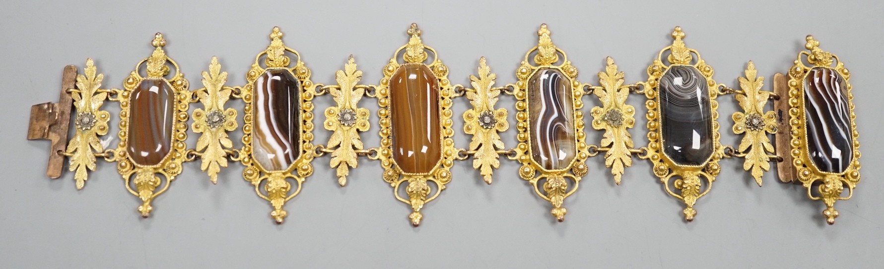 An ornate late Victorian pinchbeck and six stone banded agate set bracelet, 18.5cm.